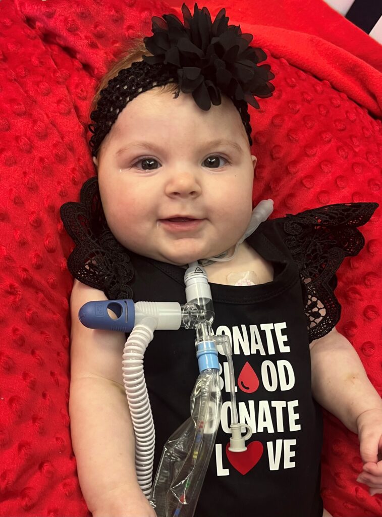 Baby Sarah with a t-shirt reading Donate Blood, Donate Love.